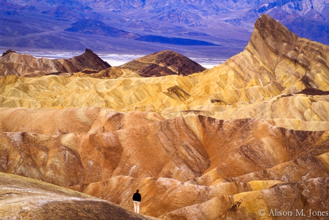 California: Death Valley National Park, view from Zabriskie Point with tourist enjoying overlook, January.